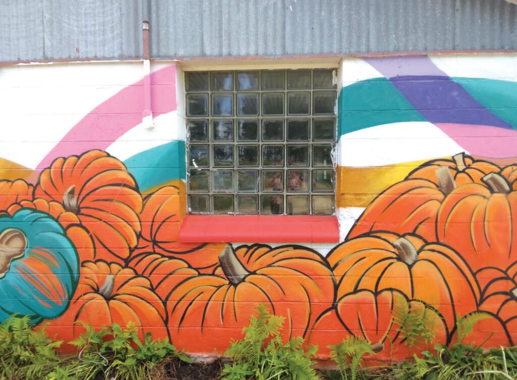 A mural of pumpkins painted on an exterior barn wall at Driftless Curiosity