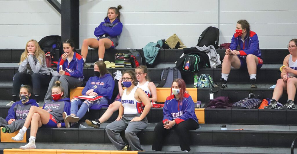 Decorah’s girls’ wrestlers watch a teammate on the mat. Decorah is one of more than 50 schools statewide that petitioned - and succeeded in getting – the Iowa Girls Athletic Union to sanction
girls’ wrestling. / Photo courtesy Melissa Simon